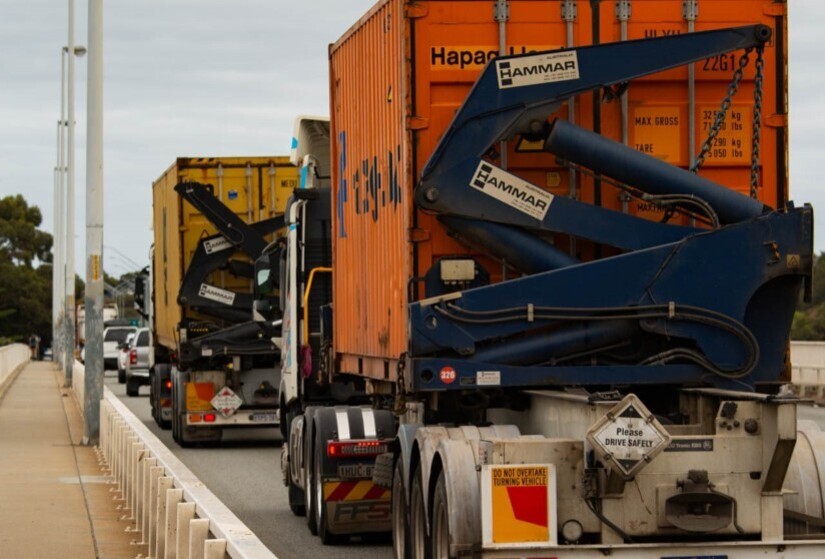 Photo of container trucks on a busy road.