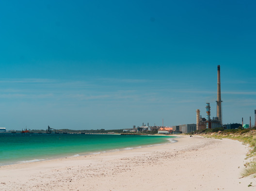 Two horses being led by a rider on to a horse beach.