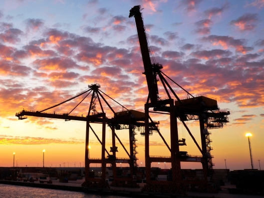 Photo of ship to shore cranes at sunset.