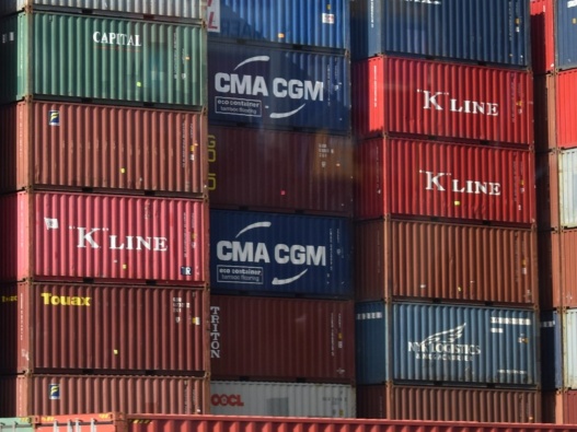 Vertical stacks of shipping containers of shipping containers all grouped together.