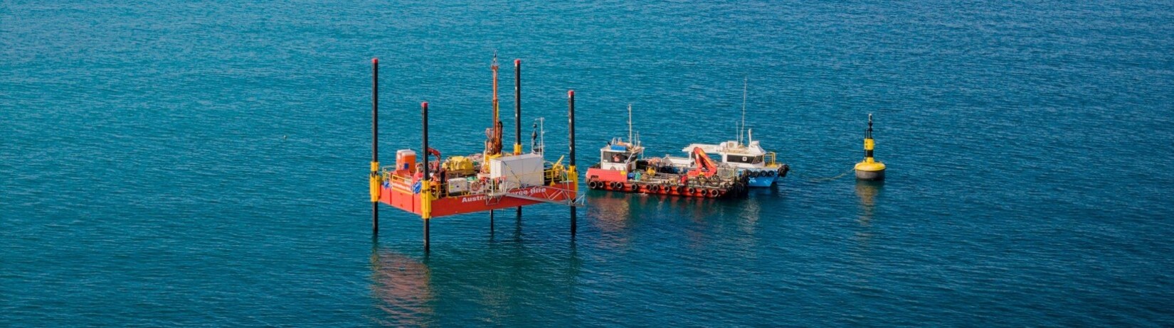 Photo of a barge and small vessel in the Cockburn Sound.