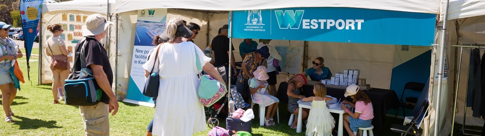 Westport team members chatting with community members under a Westport branded pavillion