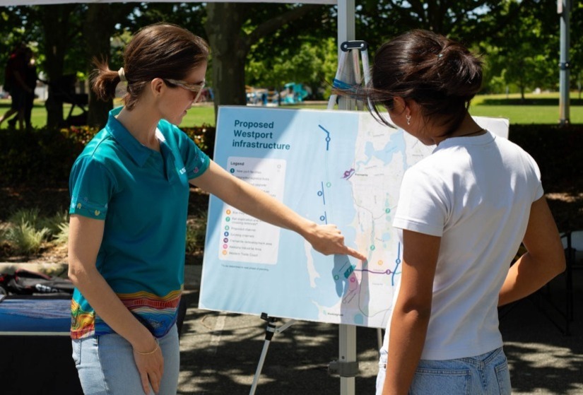 Westport staff member pointing to a map of the Proposed Westport Infrastructure with a community member.