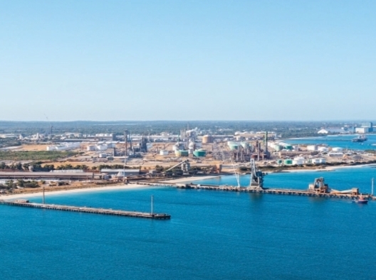 Aerial photo of the Kwinana Industrial Area from the see, two jetties are in the foreground.