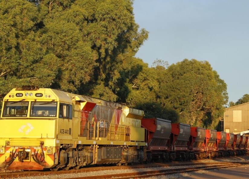 Photo of the side of a train and its industrial carriages