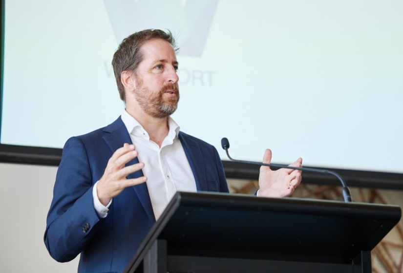 Patrick Seares presenting in front of a lectern at a conference.