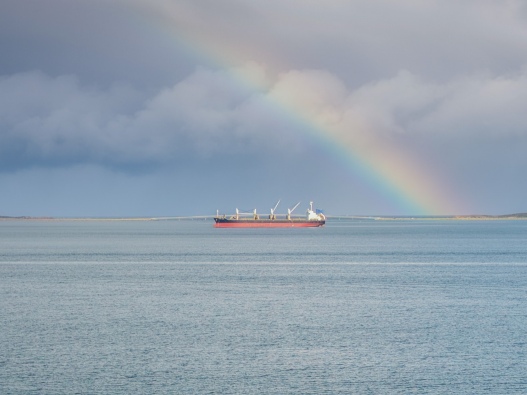Photo of a vessel in the Cockburn Sound, with a rainbow in the background. 