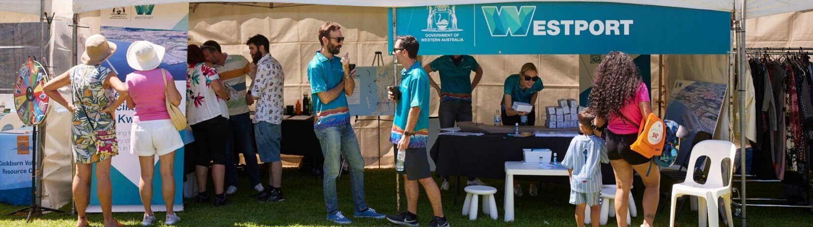 Westport team members chatting with community members under a Westport branded pavillion