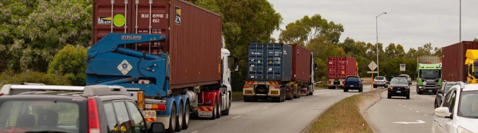 Photo of container trucks on a busy road.