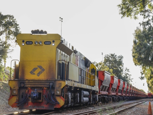 Photo of the side of a train and its industrial carriages